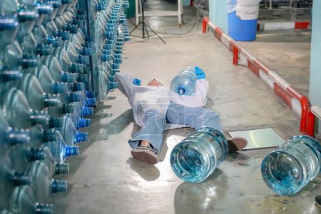 Photo for Woman get accidented inside storages floor. RO system for industry, equipment which popular to install with pipe at industrial such chemical, power plant. Young happy female worker in bottling factory checking water bottles - Royalty Free Image