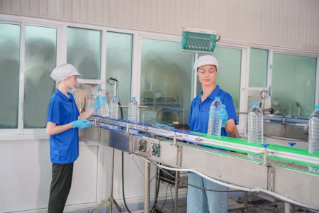 Photo for Woman working at Reverse osmosis system for power plant. RO system for industry, equipment which popular to install with pipe at industrial such chemical, power plant. Young happy female worker in bottling factory checking water bottles - Royalty Free Image
