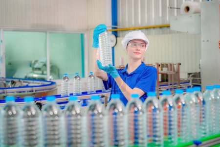 Photo for Woman working at Reverse osmosis system for power plant. RO system for industry, equipment which popular to install with pipe at industrial such chemical, power plant, oil and gas. Young happy female worker in bottling factory checking water bottles - Royalty Free Image