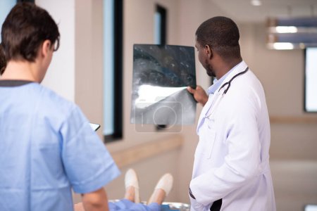 Téléchargez les photos : Médecins examinant les rayons X dans le couloir de l'hôpital - en image libre de droit