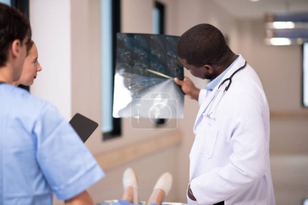 Médicos examinando rayos X en corredor del hospital
