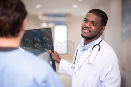 Photo for Doctors examining x-ray in corridor of hospital - Royalty Free Image