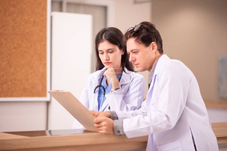 Photo for Working with documents. Two doctors in white coats is in the clinic - Royalty Free Image