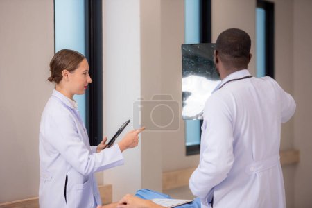 Téléchargez les photos : Médecins examinant les rayons X dans le couloir de l'hôpital - en image libre de droit