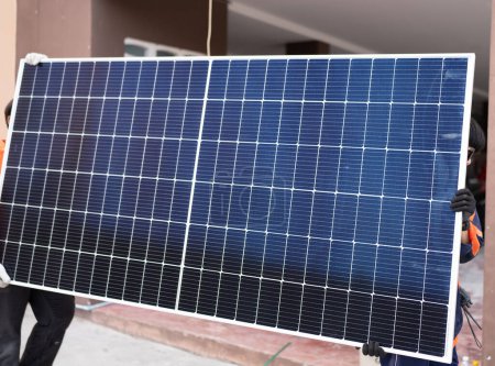 Foto de Primer plano del panel solar, el trabajador lleva el panel de sorlar a la instalación. - Imagen libre de derechos