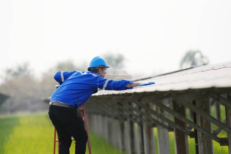 Foto de Ingeniero electricista con casco trabajando en una granja fotovoltaica, equipos de control y mantenimiento con instrumentos en la industria de energía solar. - Imagen libre de derechos