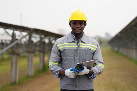 Foto de Ingeniero electricista con casco blanco que trabaja en una granja fotovoltaica, equipos de control y mantenimiento con instrumentos en la industria de energía solar. - Imagen libre de derechos