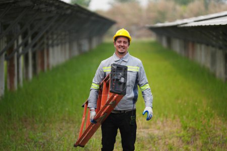 Foto de Ingeniero electricista con casco blanco que trabaja en una granja fotovoltaica, equipos de control y mantenimiento con instrumentos en la industria de energía solar. - Imagen libre de derechos