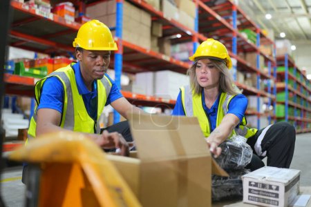 Foto de Trabajadores que trabajan en grandes almacenes, marcando cajas envueltas - Imagen libre de derechos