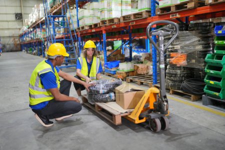 Photo for Workers working in large warehouse, checking wrapped boxes - Royalty Free Image