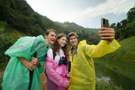 Téléchargez les photos : Les jeunes prenant des photos selfie, s'amusant pendant la randonnée dans la forêt - en image libre de droit
