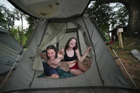 Foto de Feliz pareja de amantes descansando en el campamento forestal - Imagen libre de derechos