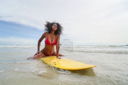 Photo for Young Woman swimming on surfboard - Royalty Free Image