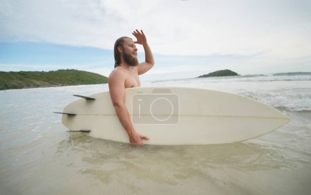 Photo for Handsome young man swimming on surfboard - Royalty Free Image