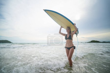 Foto de Mujer sexy posa con tabla de surf en la playa - Imagen libre de derechos