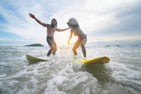 Photo for Happy couple surfing together on beach with surfing board in Pattaya, Thailand. - Royalty Free Image