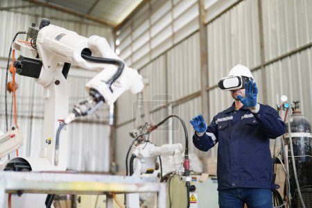 Téléchargez les photos : Ingénieur industriel utilisant casque VR tout en travaillant à l'usine de production robotique IA automatisée, Nouveau concept de technologie industrielle. - en image libre de droit