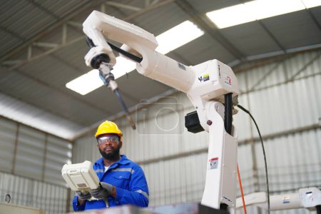 Foto de Ingeniero industrial que trabaja en la fábrica automatizada de producción robótica AI, nuevo concepto de tecnología industrial. - Imagen libre de derechos