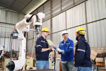 Foto de Ingenieros industriales multirraciales que trabajan en la fábrica automatizada de producción robótica de IA, nuevo concepto de tecnología industrial. - Imagen libre de derechos