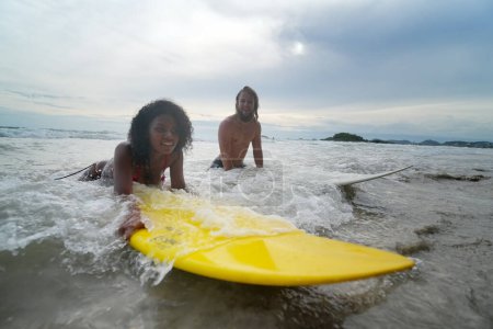 Téléchargez les photos : Joyeux couple surfant ensemble sur la plage avec planche de surf à Pattaya, Thaïlande. - en image libre de droit