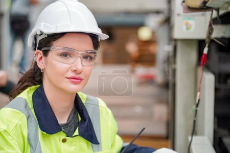 Photo for Industrial worker indoors in factory. Young technician with orange hard hat. Smart Caucasian factory worker wearing hardhat and working in power plant. - Royalty Free Image