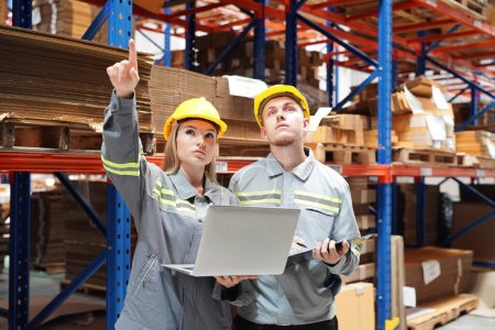 Photo for Warehouse Industrial supply chain and Logistics Companies inside. Warehouse workers checking the inventory. Products on inventory shelves storage. Workers Doing Inventory in Warehouse - Royalty Free Image