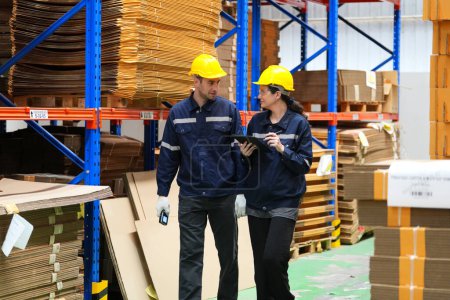 Photo for Warehouse Industrial supply chain and Logistics Companies inside. Warehouse workers checking the inventory. Products on inventory shelves storage. Worker Doing Inventory in Warehouse. Dispatcher in uniform making inventory in storehouse. supply chain - Royalty Free Image
