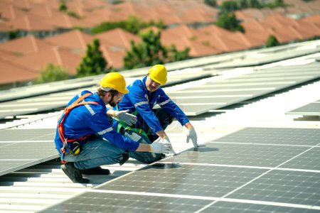 Photo for Professional engineers checking solar roof on factory rooftop under sunlight. Engineers having service job of electrical renewable eco energy - Royalty Free Image