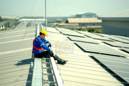 Photo for Professional engineer checking solar roof panel on the factory rooftop under sunlight. Engineer having service job of electrical renewable eco energy - Royalty Free Image