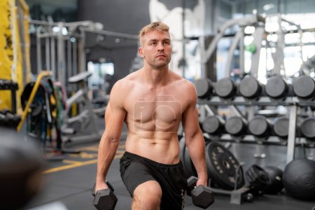 Téléchargez les photos : Jeune homme en forme beau dans la salle de gym de travail - en image libre de droit