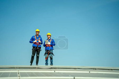 Photo for Professional engineers checking solar roof on factory rooftop under sunlight. Engineers having service job of electrical renewable energy - Royalty Free Image