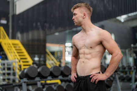 Téléchargez les photos : Jeune homme en forme beau dans la salle de gym de travail - en image libre de droit