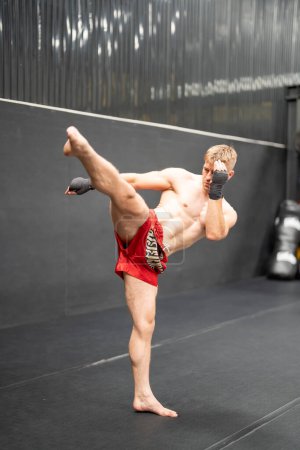 Téléchargez les photos : Athlète torse nu sportif caucasien portant des gants de boxe, faisant de l'exercice de boxe - en image libre de droit
