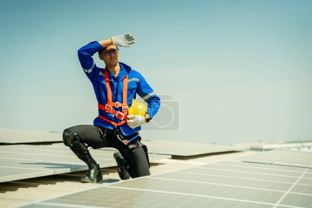 Foto de Ingeniero profesional comprobando el panel del techo solar en la azotea de la fábrica bajo la luz del sol. Ingeniero que tiene trabajo de servicio de energía eléctrica renovable eco - Imagen libre de derechos