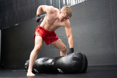 Photo for Caucasian sporty shirtless athlete wearing boxing gloves, doing boxing workout exercise - Royalty Free Image