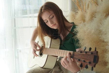 Photo for Teenage girl playing acoustic guitar - Royalty Free Image