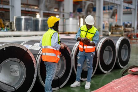Photo for Two highly professional technicians wearing overalls and hardhats at production department of modern plant and discussing ideas - Royalty Free Image