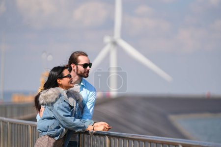 Photo for Happy couple of lovers in the wind turbine background - Royalty Free Image