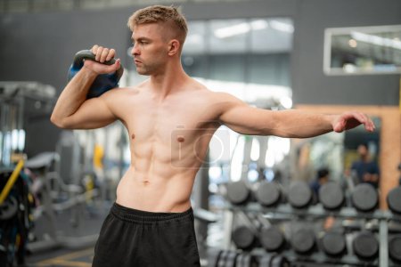 Foto de Joven hombre guapo en forma en el gimnasio haciendo ejercicio - Imagen libre de derechos
