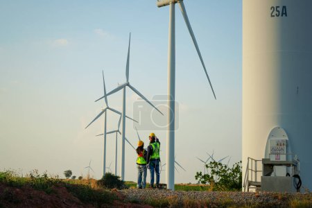Téléchargez les photos : Surveyor et ingénieur Examiner l'efficacité de gigantesques éoliennes - en image libre de droit