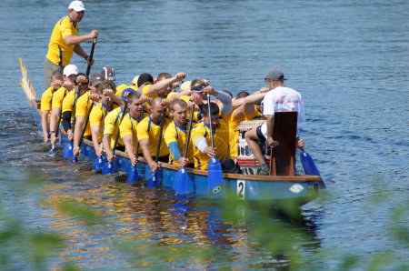 Photo for Oarsmen rowing dragonboat on a river. Kyiv oblast championship among amateurs. May 25, 2019. Kyiv, Ukraine - Royalty Free Image