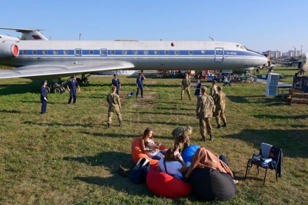 Photo for Young people soldiers, pilots and stewardesses playing volleyball, landed aircraft on a background. June 12, 2019. Kyiv, Ukraine - Royalty Free Image