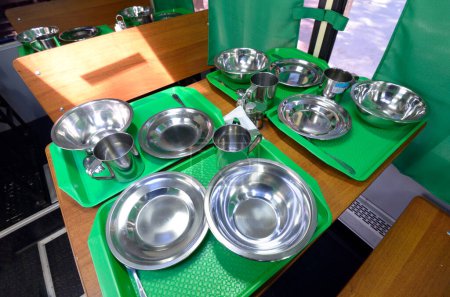 Téléchargez les photos : Tables servies avec vaisselle en métal dans la cantine mobile pour les soldats. Staroe, Ukraine. - en image libre de droit