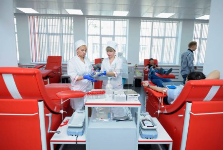 Foto de Mujeres enfermeras preparando equipo médico para transfusión de sangre, donantes acostados en camas de donantes. Estación municipal de transfusión de sangre. 5 de abril de 2022. Kiev, Ucrania - Imagen libre de derechos