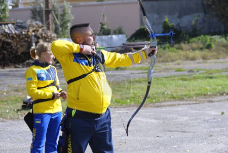 Téléchargez les photos : Homme archer tenant un arc visant sur un champ de tir tir de tir à l'arc. 25 octobre 2020. Kiev, Ukraine - en image libre de droit