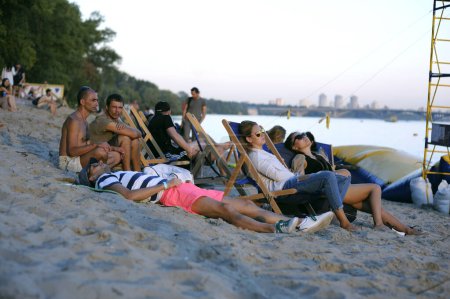 Foto de Personas sentadas en una playa y tomando el sol. Fest Vedalife. 25 de julio de 2018. Kiev, Ucrania - Imagen libre de derechos