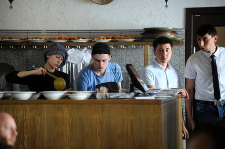 Téléchargez les photos : Restaurant tartare : travailleurs de cuisine et serveuses travaillant derrière le bar pendant que les gens mangent aux tables. 8 septembre 2018. Kiev, Ukraine - en image libre de droit