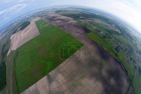 Téléchargez les photos : Vue de dessus d'une terre avec des champs et des villages depuis un panier d'une montgolfière, fisheye - en image libre de droit