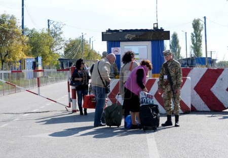 Foto de Guardia fronteriza revisando bolsas de viajeros en el paso fronterizo Kalanchak, frontera terrestre ucraniano-rusa. 20 de septiembre de 2017. Región de Kalanchak, Provincia de Khersonskaya, Ucrania - Imagen libre de derechos