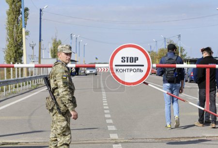 Foto de Guardia fronteriza ucraniana de pie cerca de señal Stop. El paso fronterizo Kalanchak. 20 de septiembre de 2017. Región de Kalanchak, Provincia de Khersonskaya, Ucrania - Imagen libre de derechos